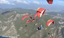 Fethiye'de üniversite öğrencileri Türk bayraklarıyla yamaç paraşütü atlayışı yaptı