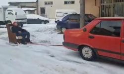 Otomobile bağladığı koltukla kayak yaptı